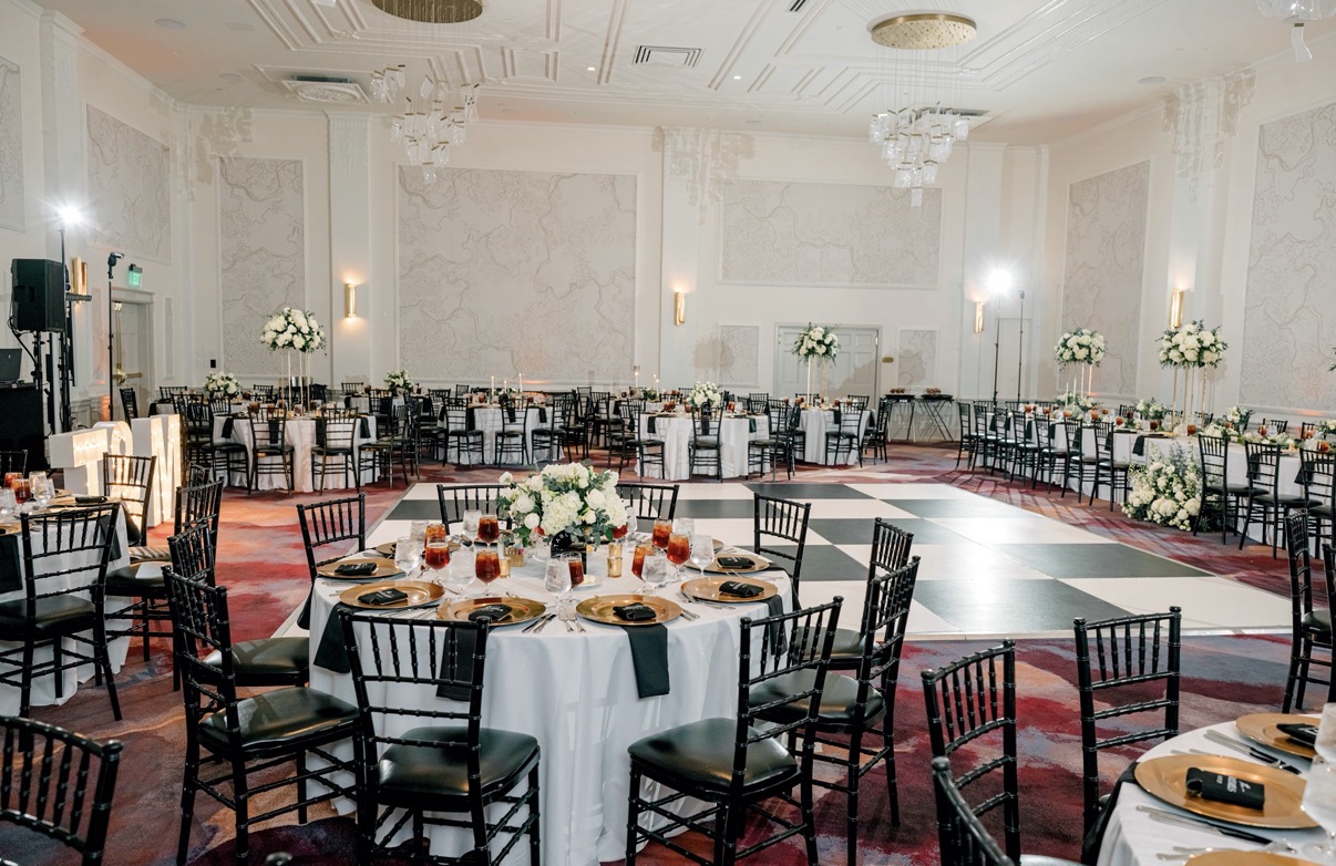 Ballroom reception with round tables and a checkered dance floor at The Gunter Hotel