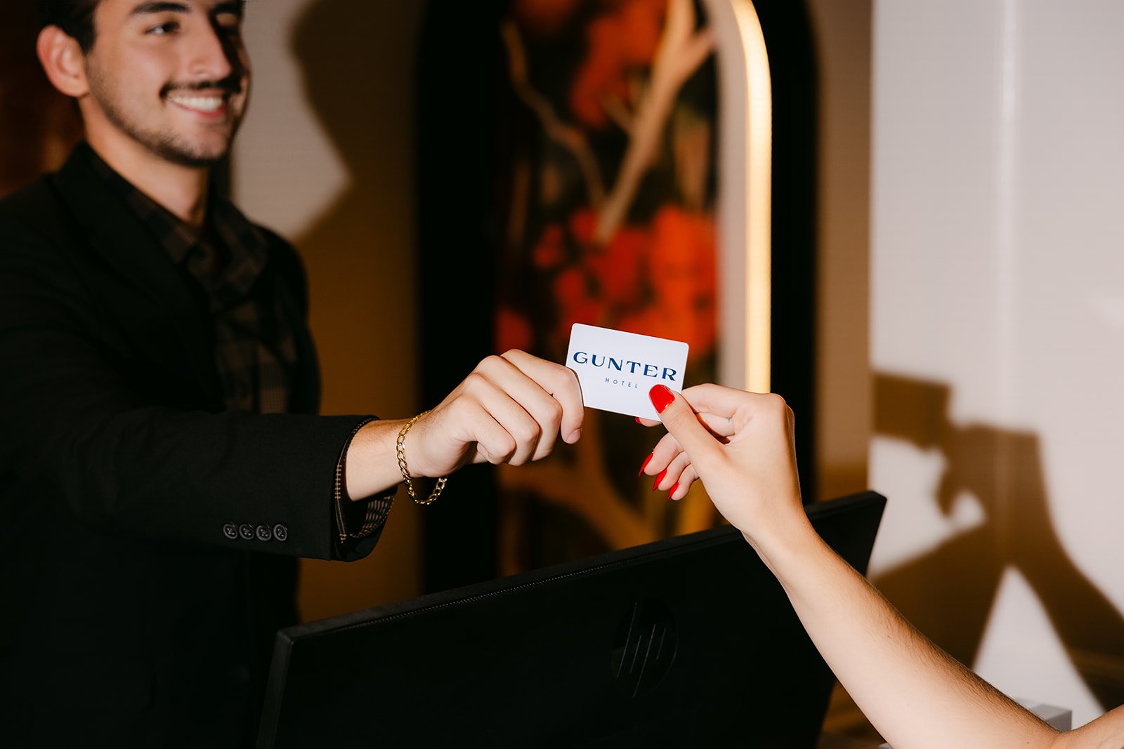 A guest receiving a room key at the front desk of The Gunter Hotel in downtown San Antonio