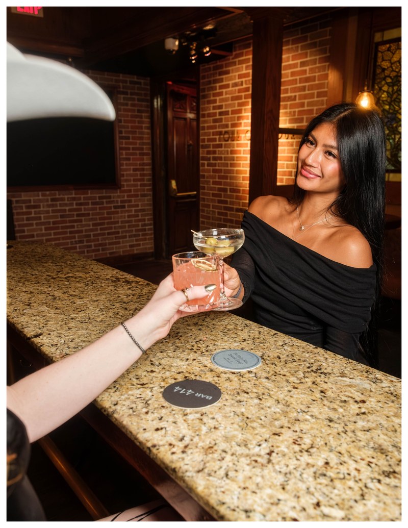 Guests toasting cocktails at Bar 414, the speakeasy-inspired bar at The Gunter Hotel