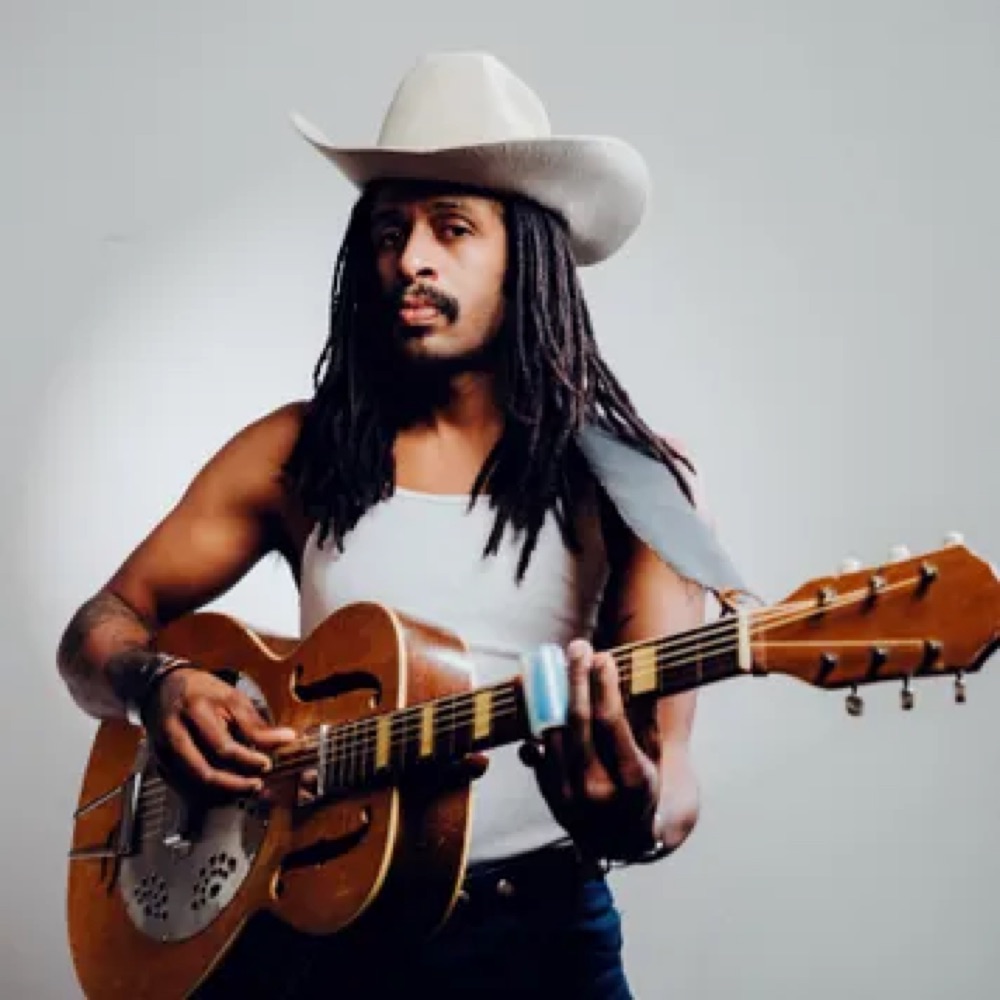 Nicky Diamonds playing a resonator guitar, performing the Robert Johnson Revue at The Gunter Hotel