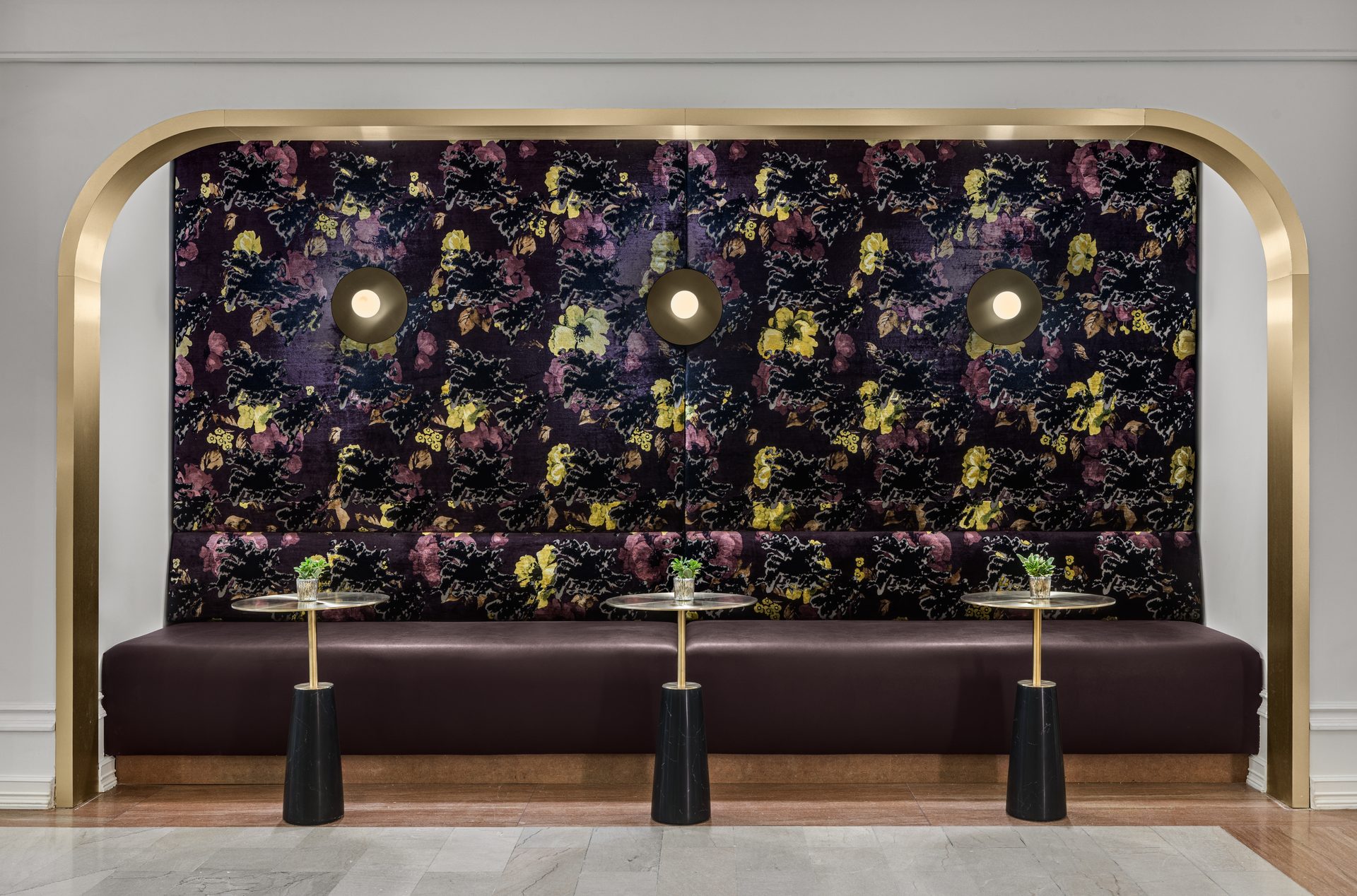 Gold-framed lobby alcove with floral wallpaper and cocktail tables at The Gunter Hotel