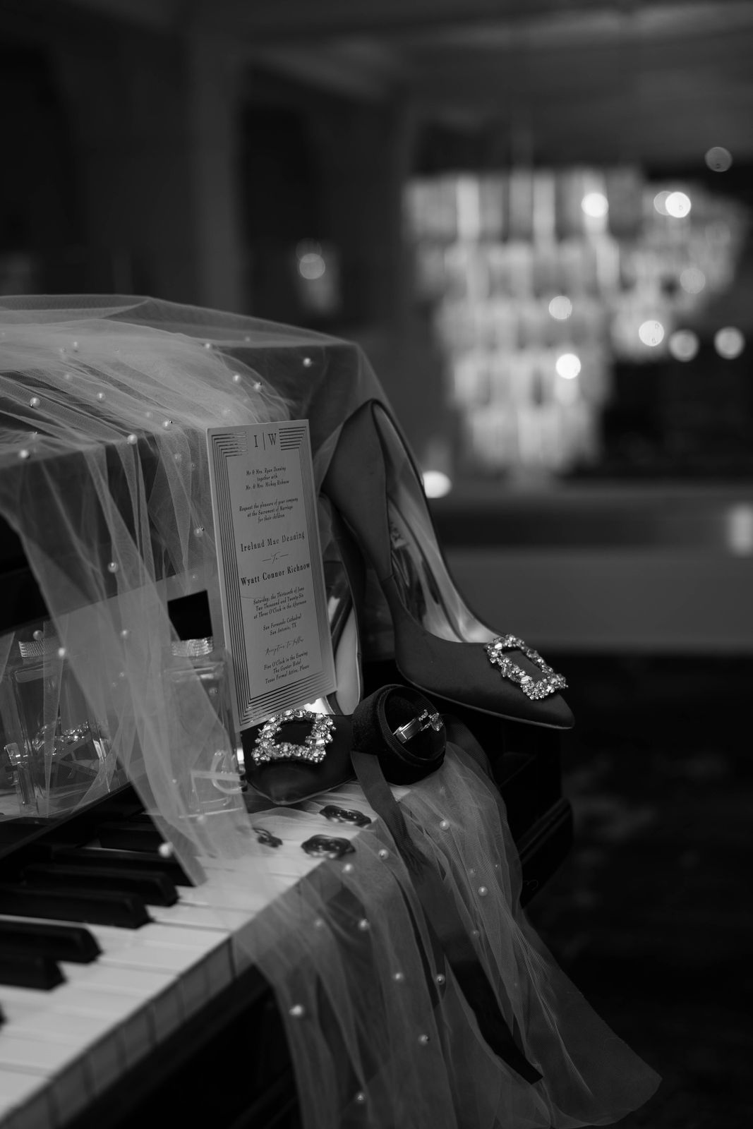 Bridal shoes and veil resting on a grand piano